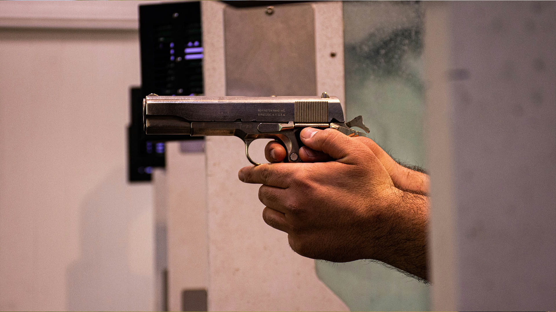 Hands holding a gun at a shooting range